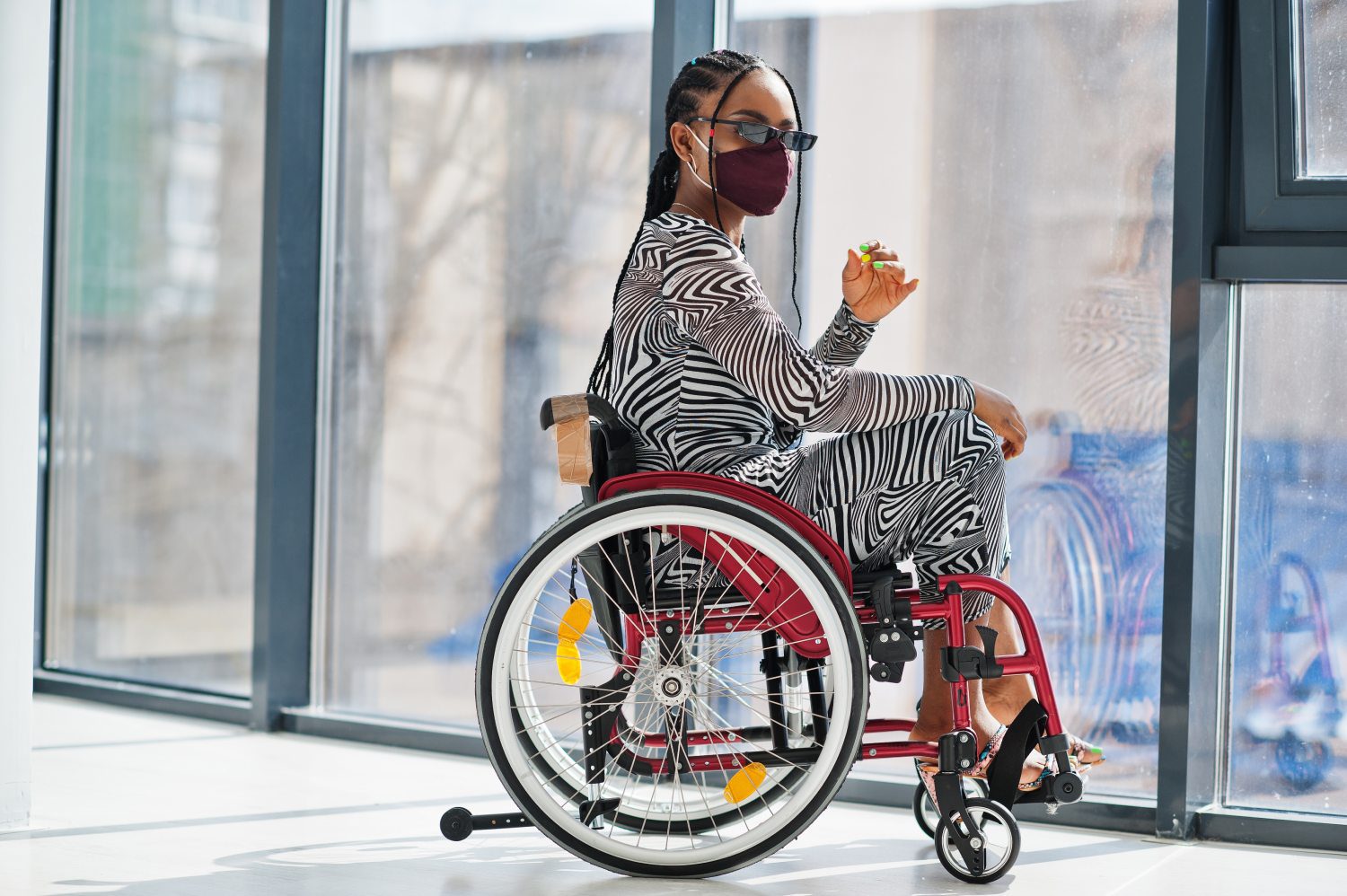 A woman in zebra print sitting on a wheelchair.