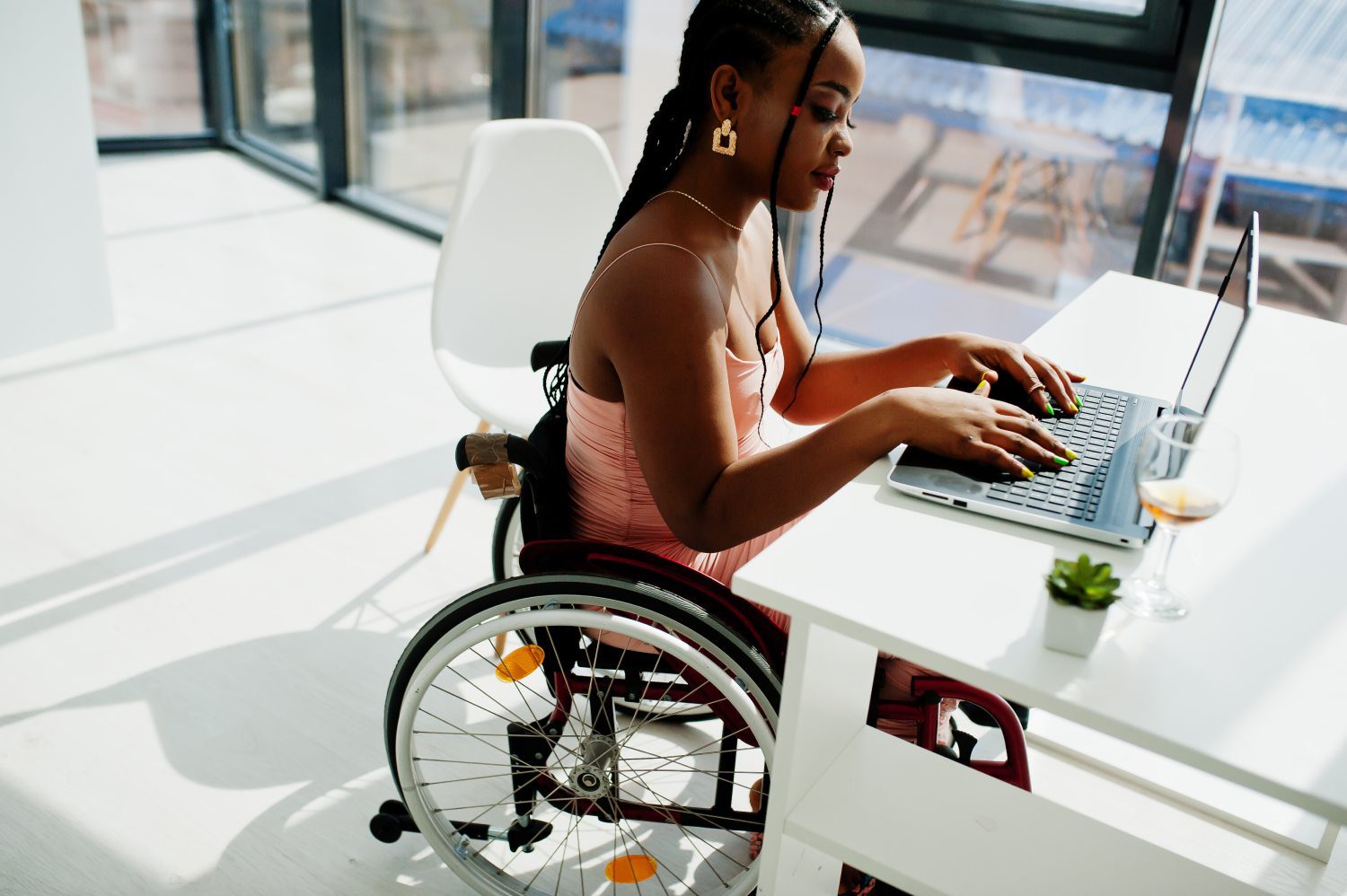 A woman in a wheelchair using her laptop.