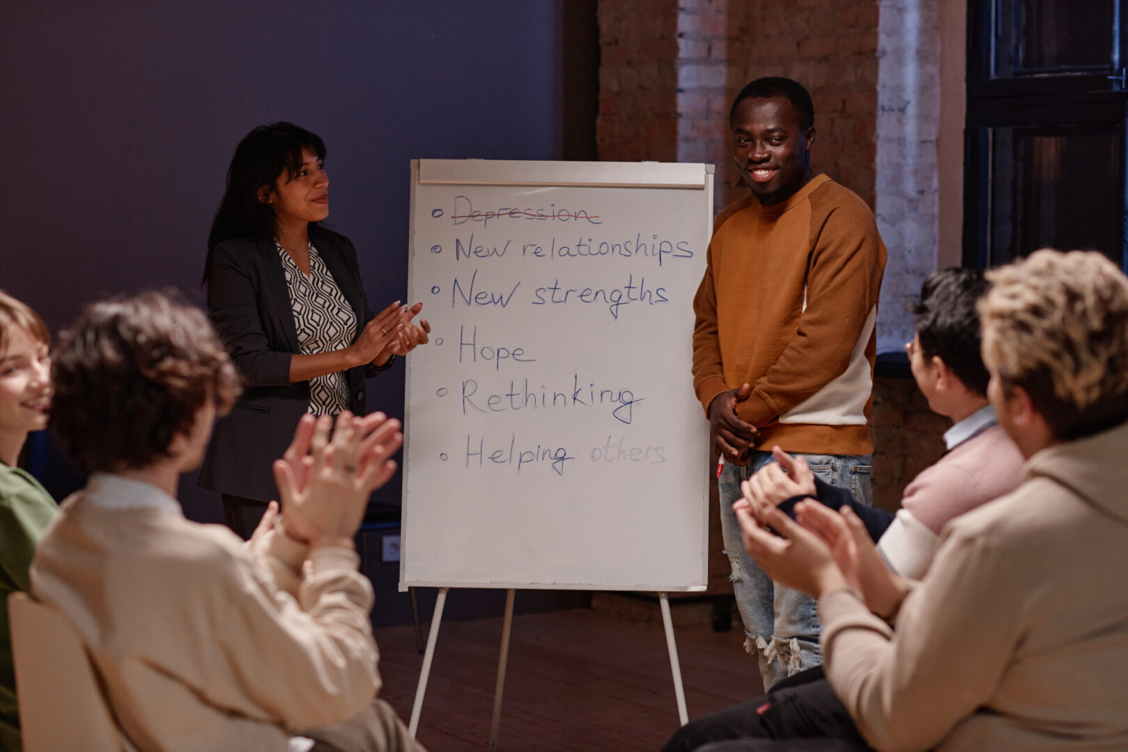 A group of people standing around a flip chart.