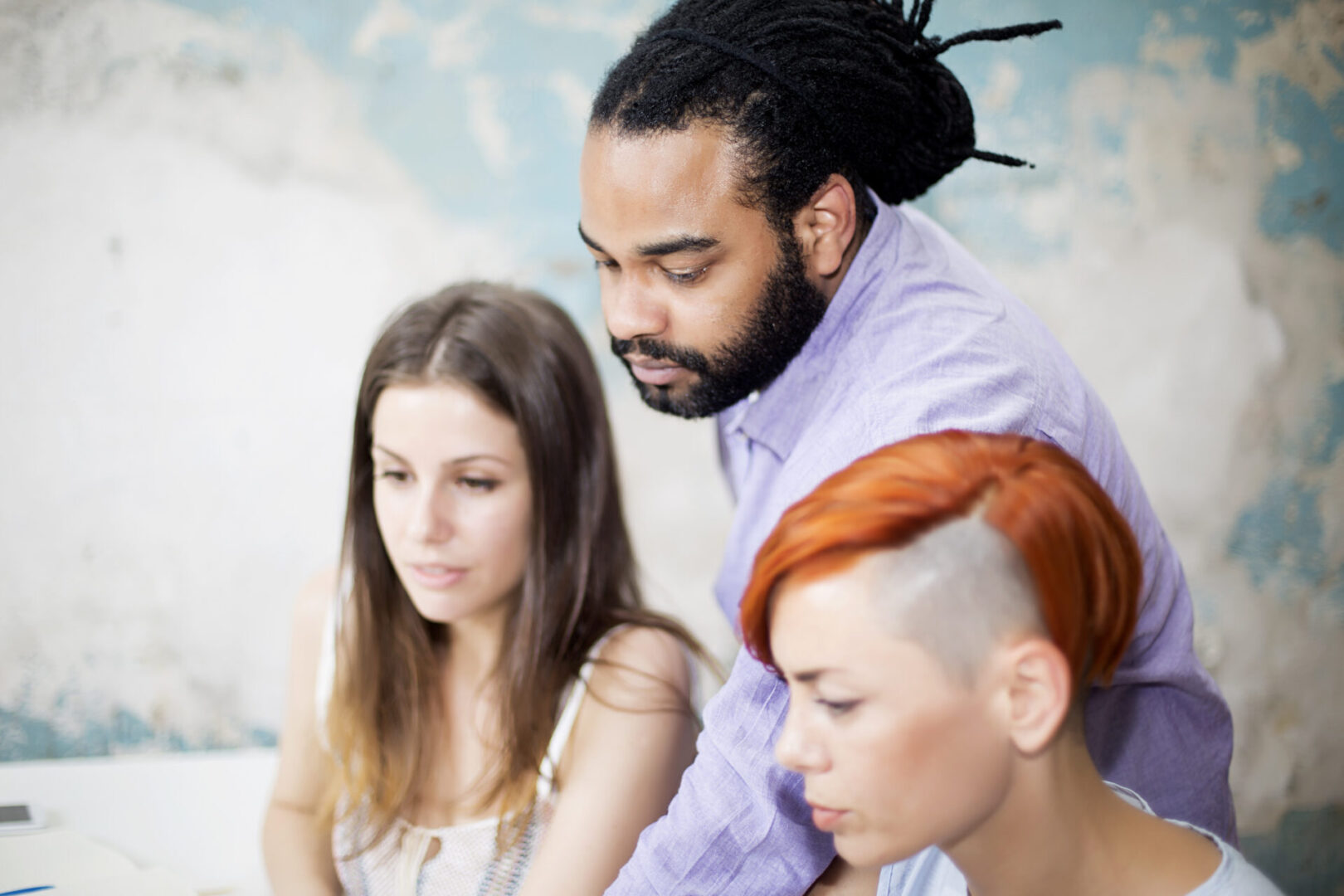 A man with dreadlocks and two women